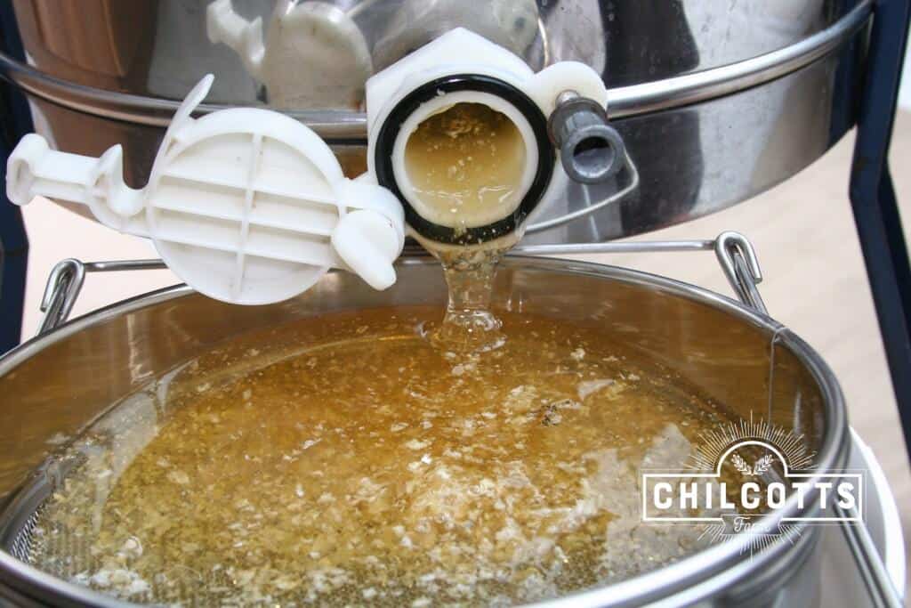 Recovered honey pours from the centrifuge extractor
